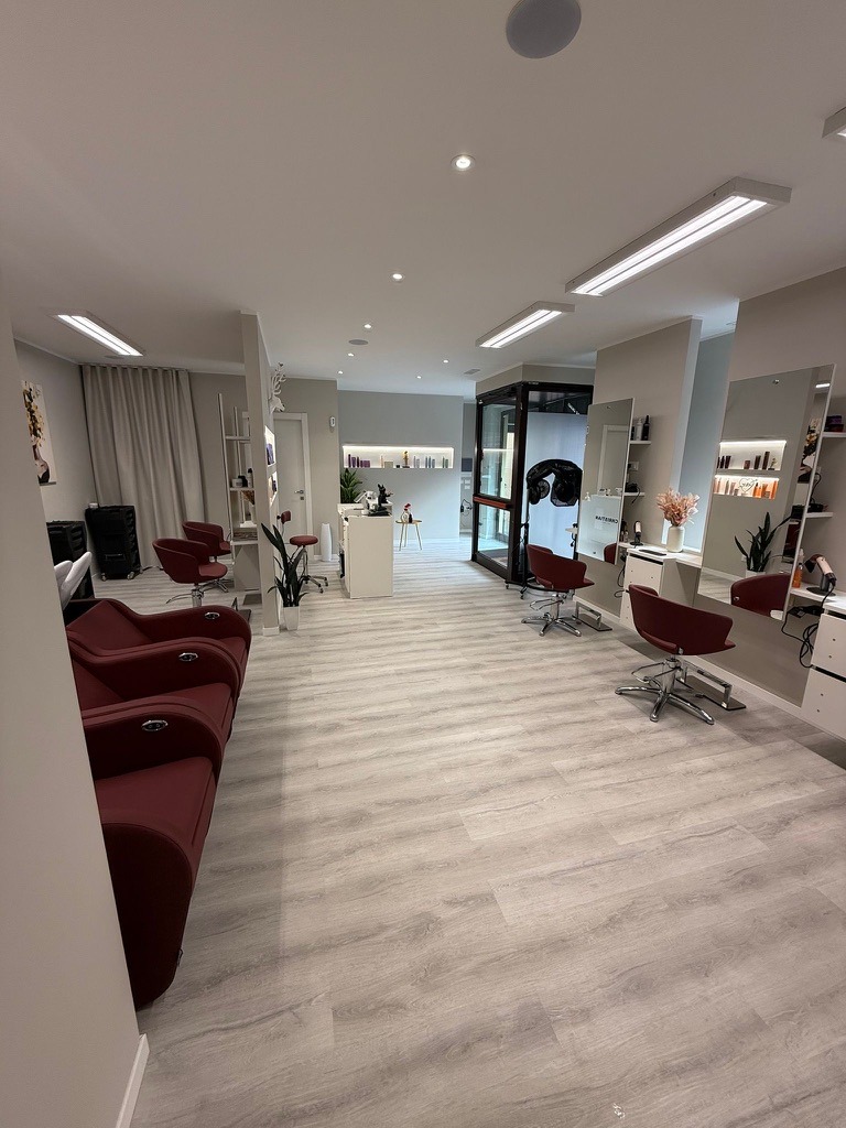 Gli interni di Christian Hair Studio a Broni, con postazioni styling e poltrone bordeaux